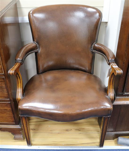 A pair of brown leather upholstered elbow chairs